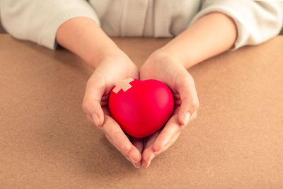 Midsection of woman holding red heart shape