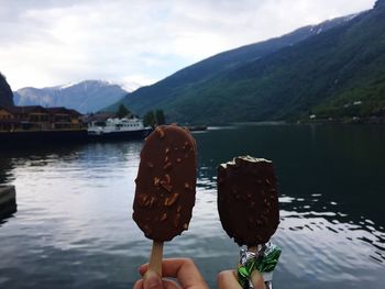 Close-up of hand holding ice cream in lake