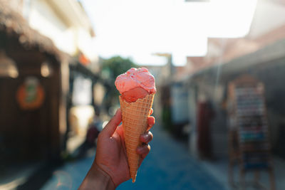 Cropped hand holding ice cream cone