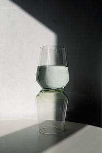 Close-up of water in glass on table against wall