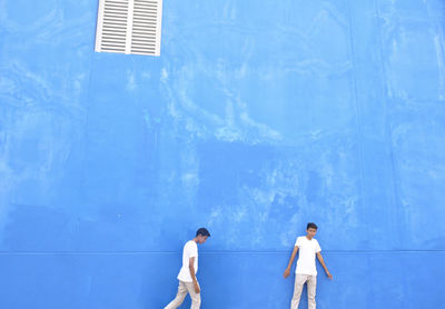 Male friends by blue wall