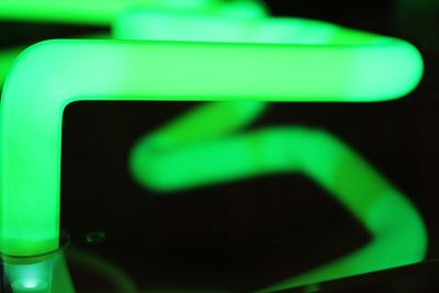 Close-up of illuminated light bulb against black background