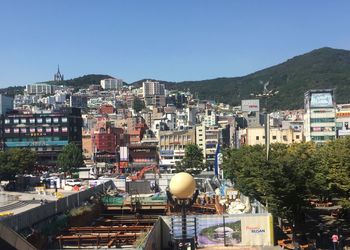 Buildings in city against clear blue sky