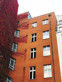 Low angle view of orange building against sky