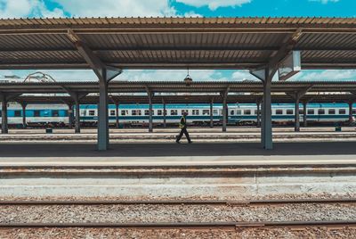 Side view of man walking on railroad station platform