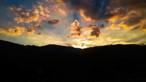 Low angle view of silhouette mountain against dramatic sky