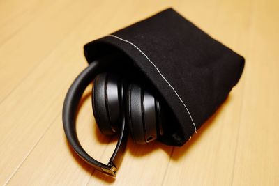 Close-up of headphones with pouch on wooden table