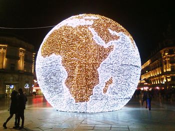 Woman in illuminated city at night