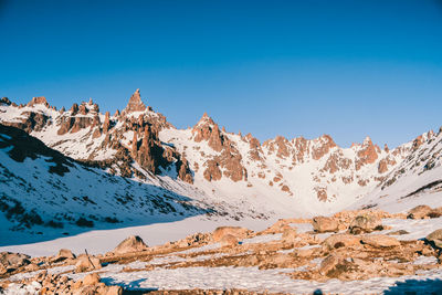 Scenic view of snowcapped mountains against clear blue sky