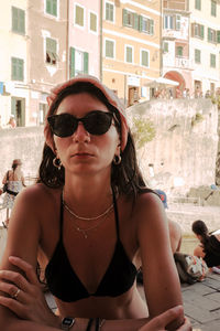 Portrait of young woman wearing sunglasses in city