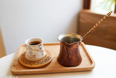 Coffee table with cup cezva and coffee grinder in the cafe