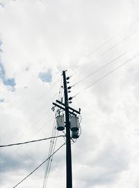 Low angle view of power lines against cloudy sky