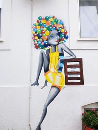 Woman with umbrella against building wall