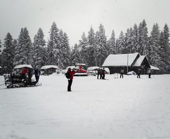 People on snow covered trees during winter