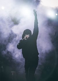 Silhouette man standing against sky at night