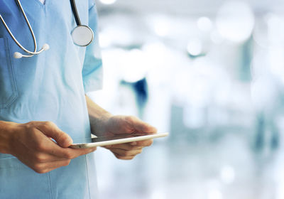 Midsection of doctor examining patient in laboratory