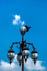 Low angle view of street light against blue sky