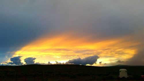 Scenic view of field against sky at sunset