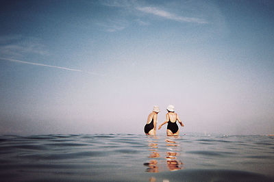 People enjoying in sea against sky