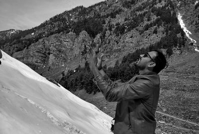 Side view of young man throwing snow