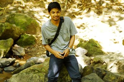 Portrait of young man standing on rock