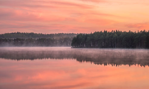 Scenic view of lake against orange sky sunset