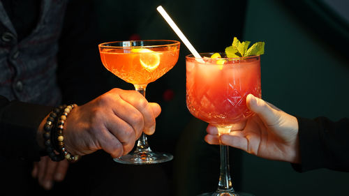 Cropped hand of woman and man holding wineglass