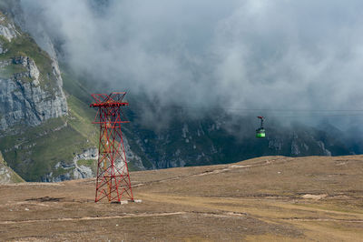 View of cross on land against mountain range