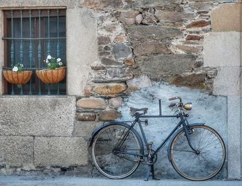 Bicycle leaning against wall of building