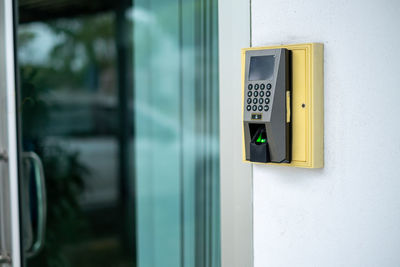 Close up finger scanner  on white wall near the office door