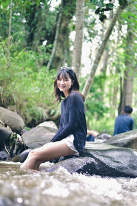 Young woman sitting on rock