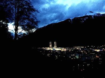 Illuminated buildings against cloudy sky