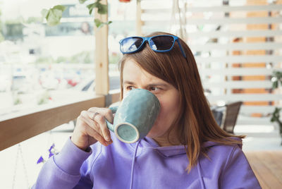 Young woman drinking coffee in cafe