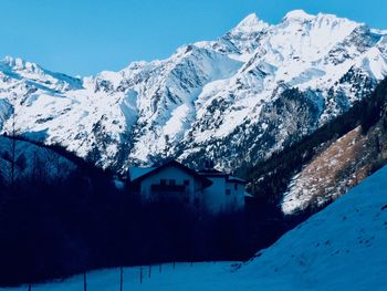 Snow covered houses and mountains against sky