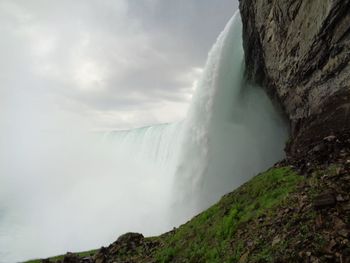Scenic view of waterfall against sky