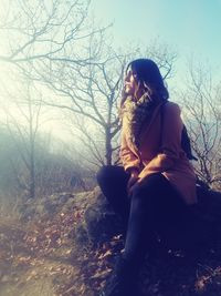 Woman sitting on snow covered land