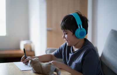 Side view of young woman working at home