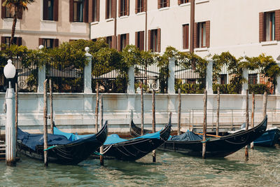 Boats moored in canal by buildings in city