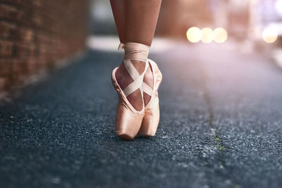 Low section of woman standing on road