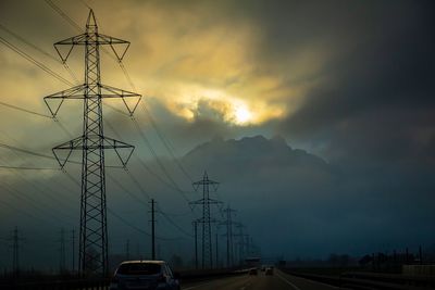 Cars on road against sky during sunset