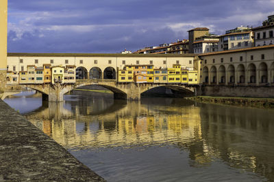 Ponte vecchio over arno river with its colorful little houses hanging - florence, tuscany, italy