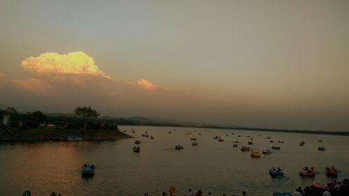 People on boat against sky during sunset