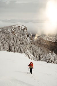 Rear view of woman skiing on snow covered mountain