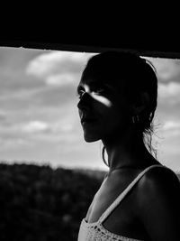 Portrait of woman looking away against sky