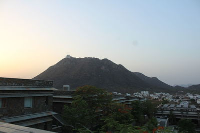 Townscape by mountains against sky