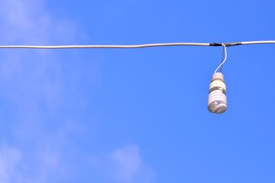 Low angle view of light bulbs against blue sky