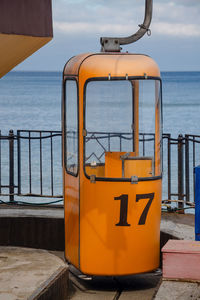 Close-up of yellow railing against sea