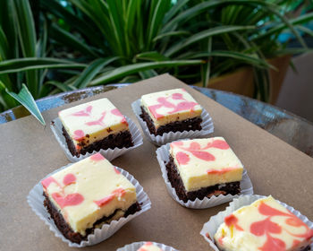 Cream cheese brownies in paper cups and wooden background