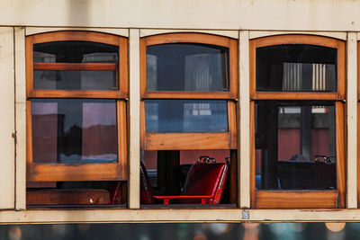 Full frame shot of glass window and red seat on antique tram