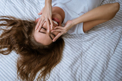 Young woman wakes up after a good night's sleep in